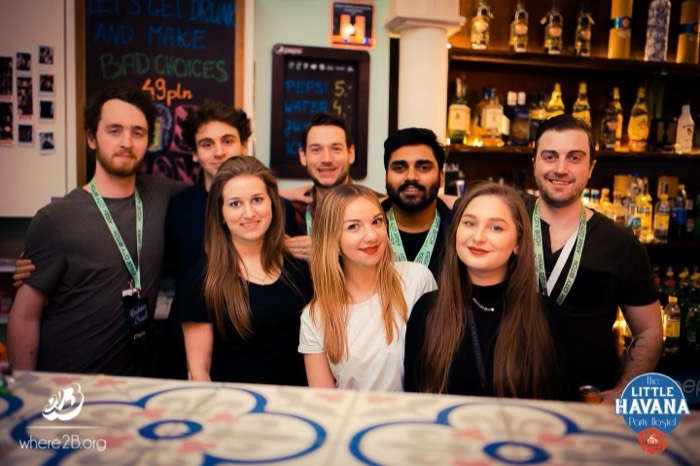 Little Havana hostel staff group portrait behind bar, Krakow