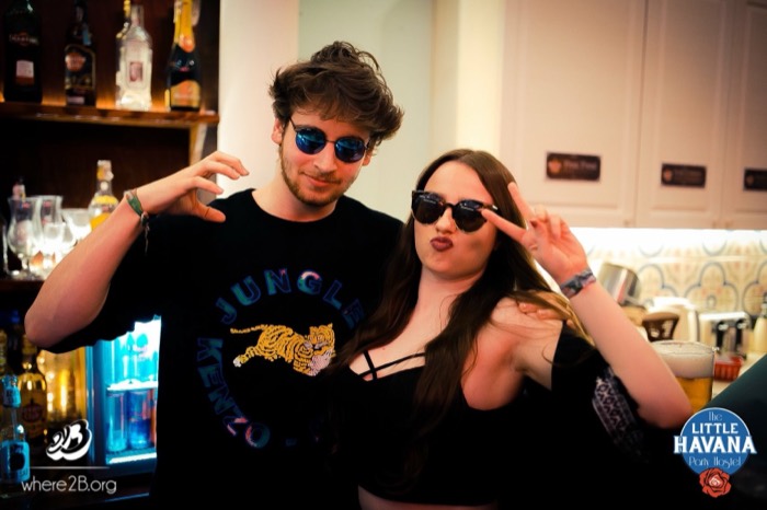 Joshua: posing in sunglasses with woman behind hostel bar