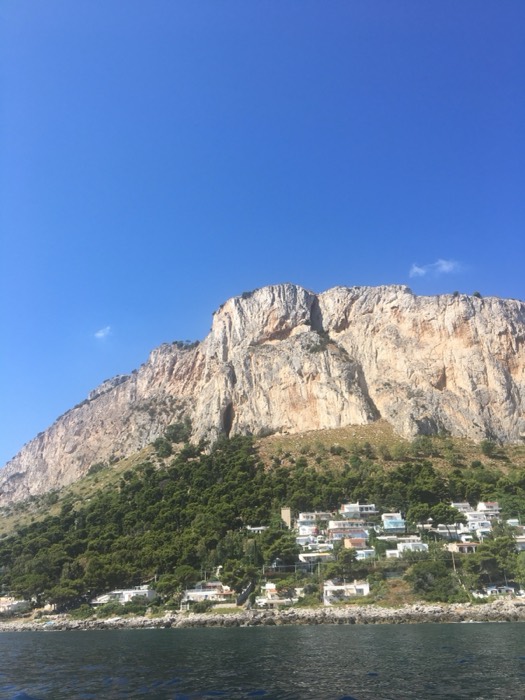 Dramatic limestone cliff and clifftop villas seen from the sea