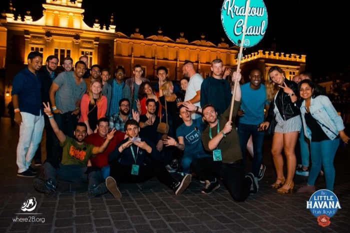 Big Krakow Crawl pub-crawl group at night, Cloth Hall behind