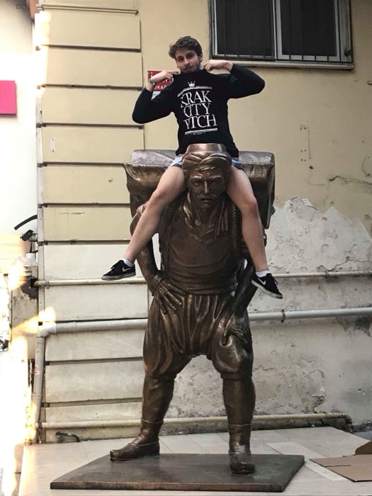 Joshua: sitting on bronze porter statue's shoulders, bazaar street