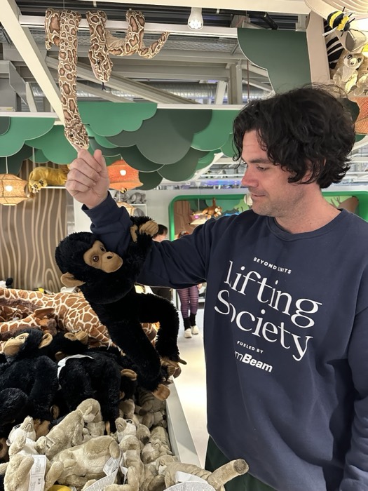 Joshua: holding stuffed monkey toy in playful jungle-themed shop display