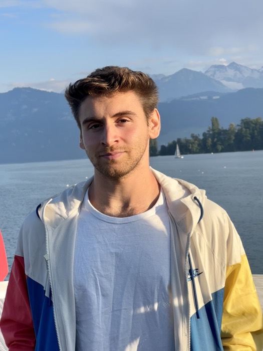 Joshua: golden-hour portrait on boat deck, lake and Alps behind