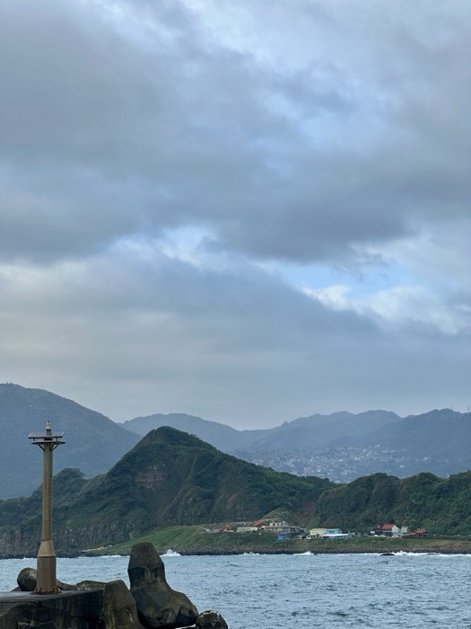 Edited copy of breakwater marker with misty mountains and town