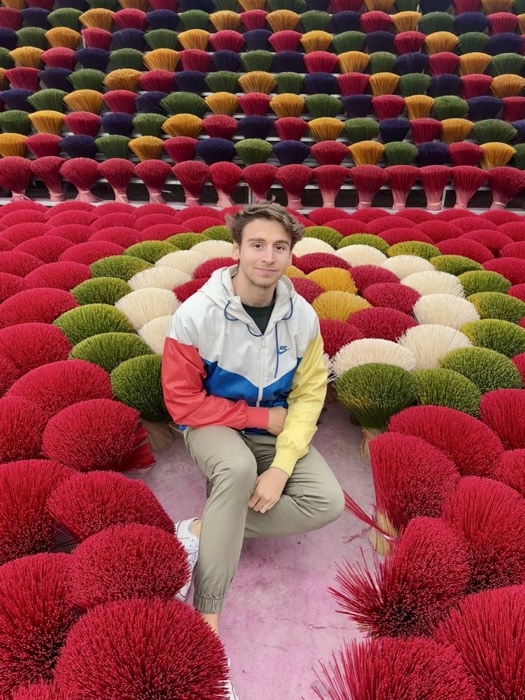 Joshua: edited duplicate, kneeling among colorful incense-stick bundles