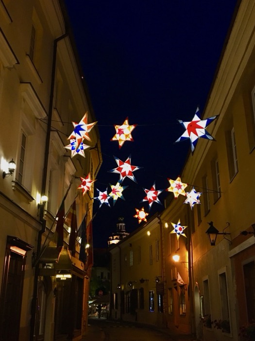 Old town alley at night strung with colorful star lanterns