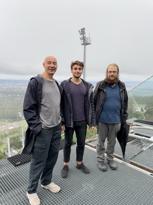Joshua: with two men on misty ski-jump tower platform above city