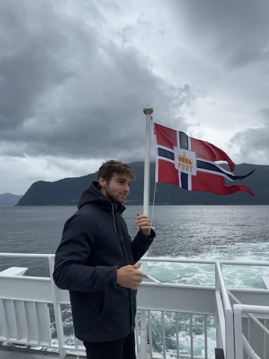 Joshua: with friend in pink on ferry stern, fjord and wake.