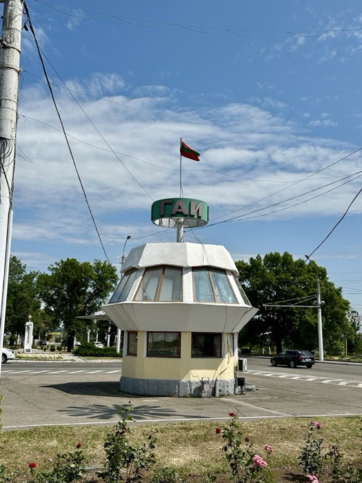 Quirky Soviet-modernist GAI traffic-police kiosk, Transnistria flag, roses