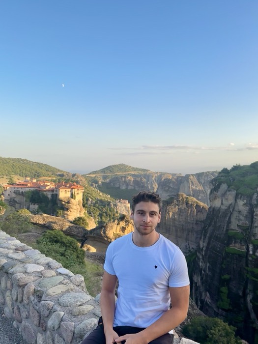 Joshua: seated before Meteora clifftop monasteries at golden hour