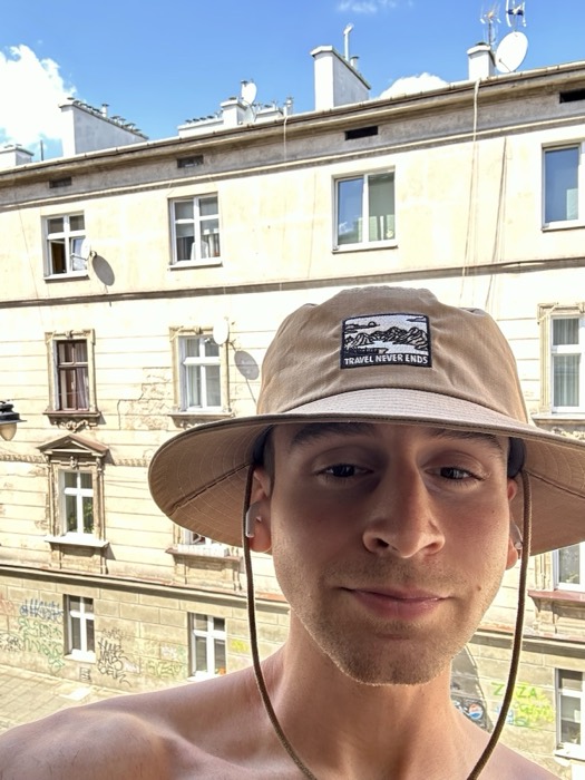 Joshua: edited duplicate of bucket-hat selfie at tenement facade