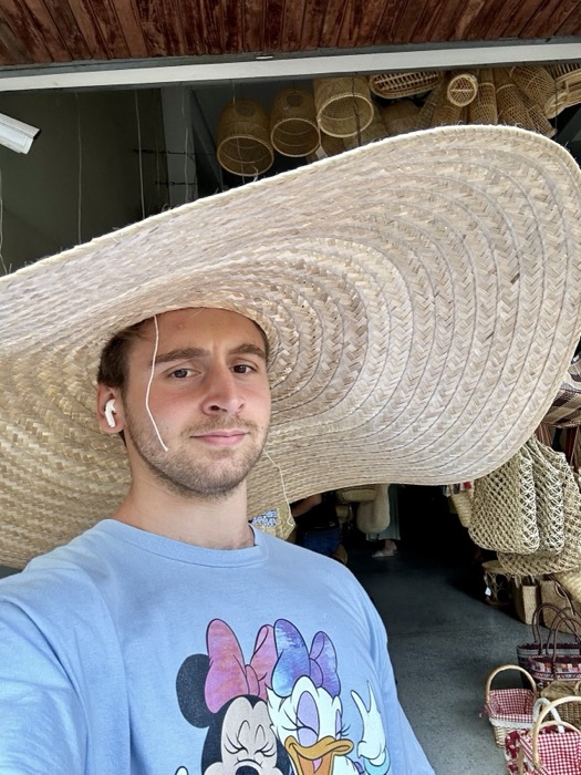 Joshua: grinning under giant woven hat at basket shop
