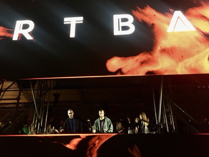 DJ set under giant flame visuals, 'RTBA' stage screen