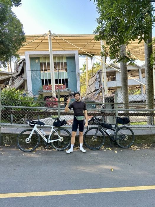 Joshua: edited duplicate, cycling kit with two bikes by collapsed building