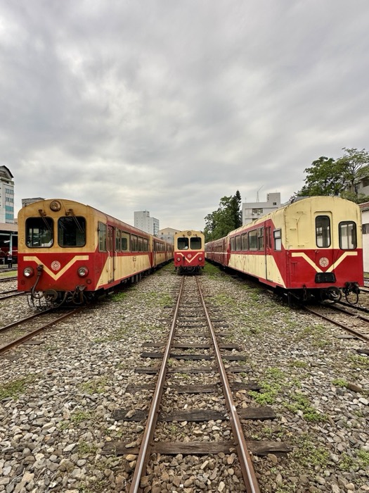 Vintage red-and-cream railcars facing down tracks, symmetrical composition