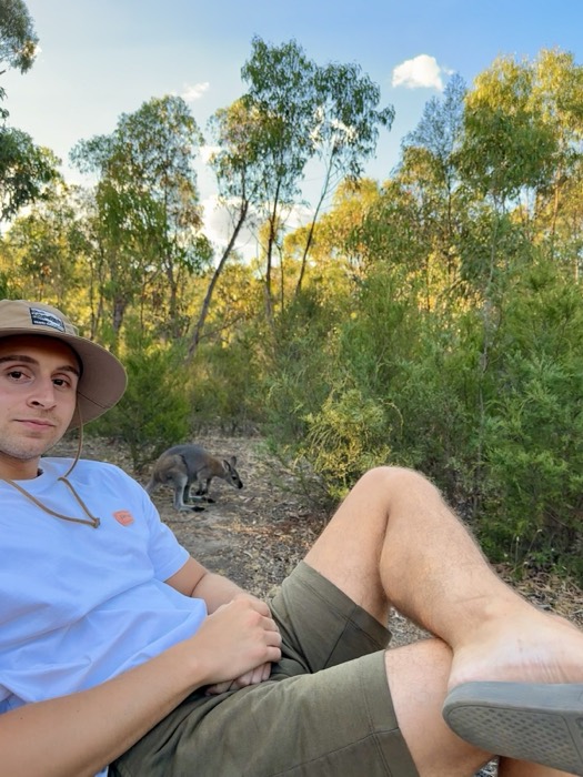 Joshua: reclining in bush, wallaby grazing behind, golden eucalypt light
