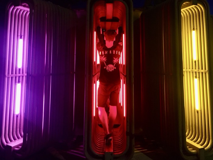Joshua: posed inside glowing red neon tube booth, purple and yellow