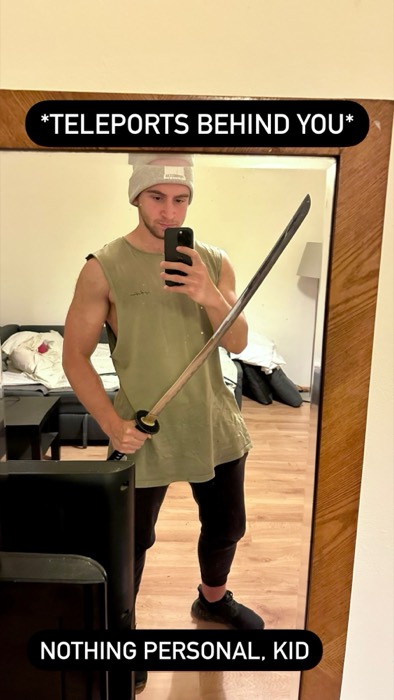 Joshua: mirror selfie in beanie wielding a katana sword