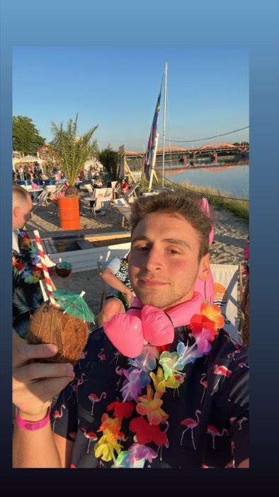 Joshua: flamingo shirt and lei, coconut drink at riverside beach bar.