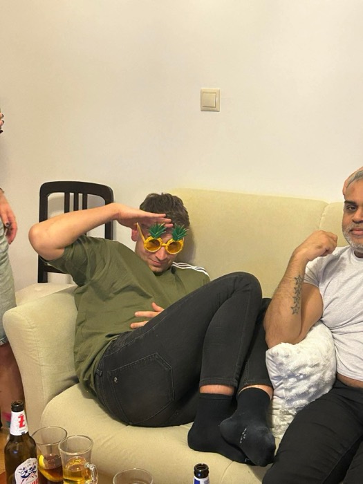 Joshua: reclining on couch in pineapple glasses, friends, party drinks
